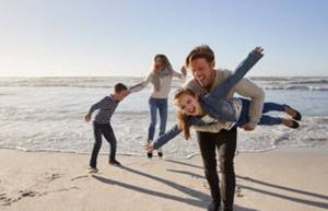 Семья веселиться на берегу моря